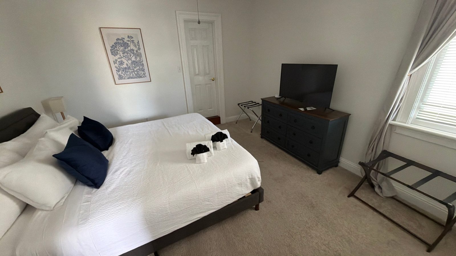 Freshly made guest bed with white linens in a short term rental